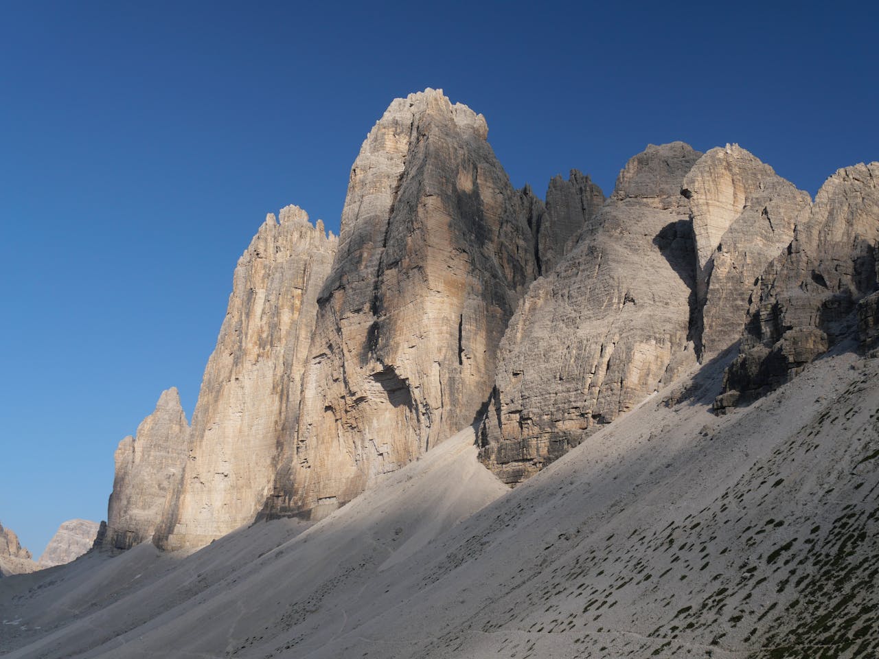 Explore the towering Tre Cime di Lavaredo in Italys Dolomites, bathed in golden evening light.